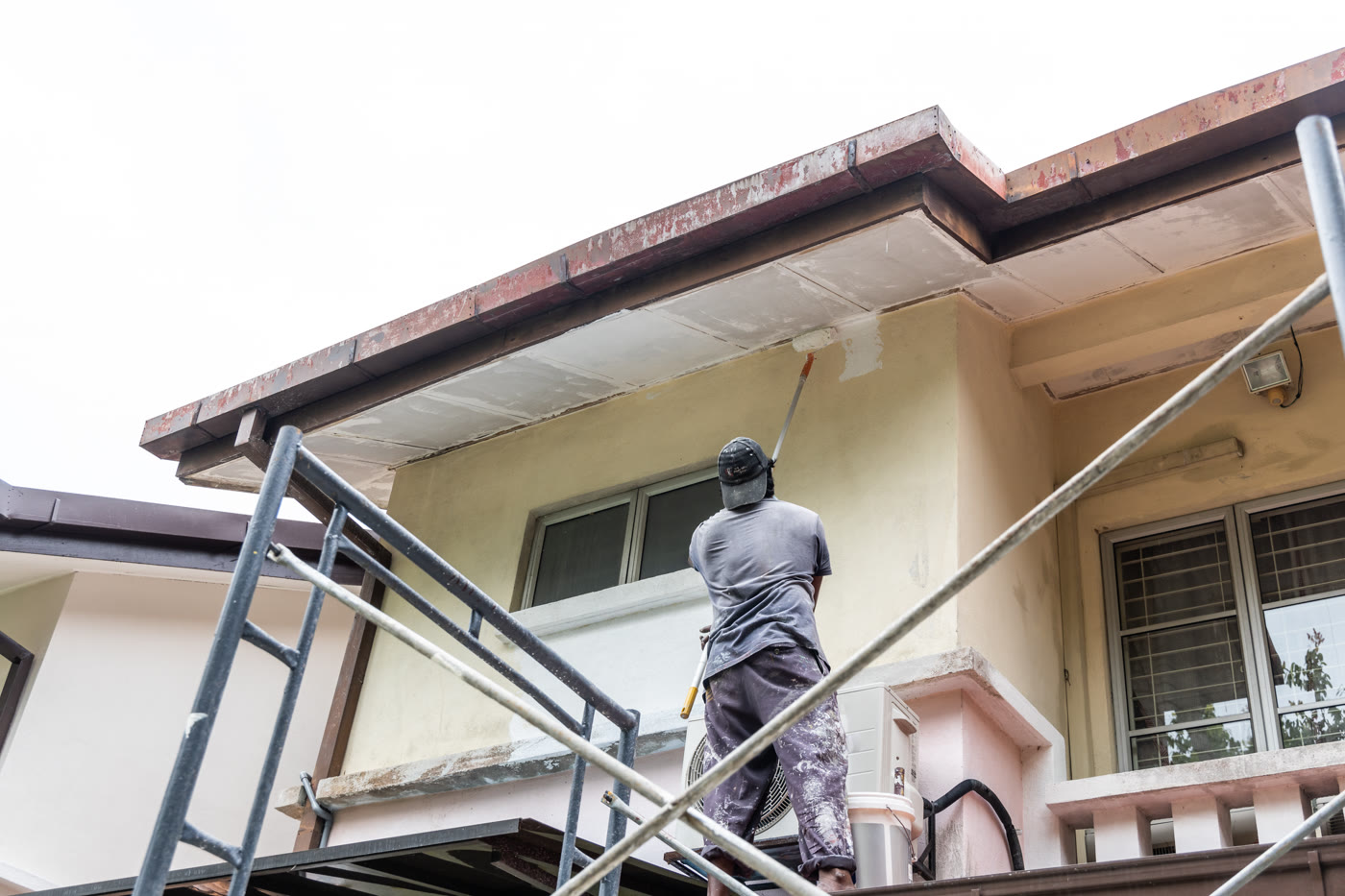 Application d'une sous-couche de peinture sur une façade, depuis un échafaudage