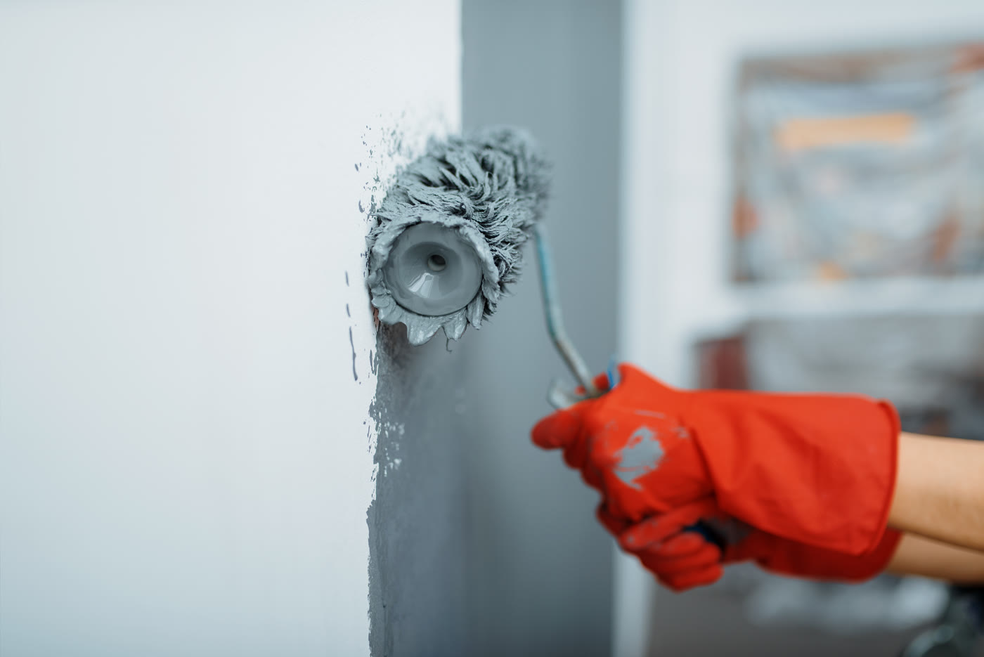 Application de peinture grise au rouleau sur un mur intérieur