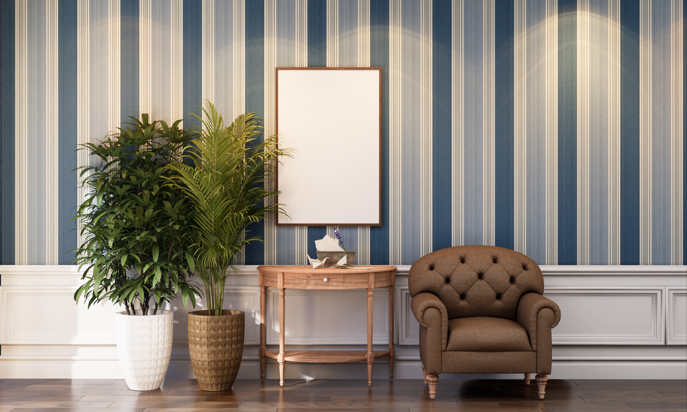 Salon avec papier peint à rayures bleu et beige, fauteuil en cuir
